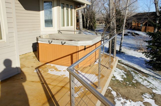 A hot tub sits on the deck, which had a railing installed.